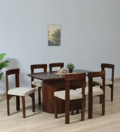 Modern wooden dining table with matching chairs and distinctive geometric legs.