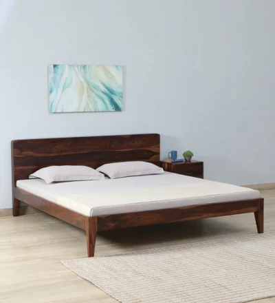 Wooden double bed with decorative carved headboard simple base